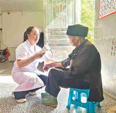 柏华丽（左）上门给老人量血压。本报记者 苏滨摄