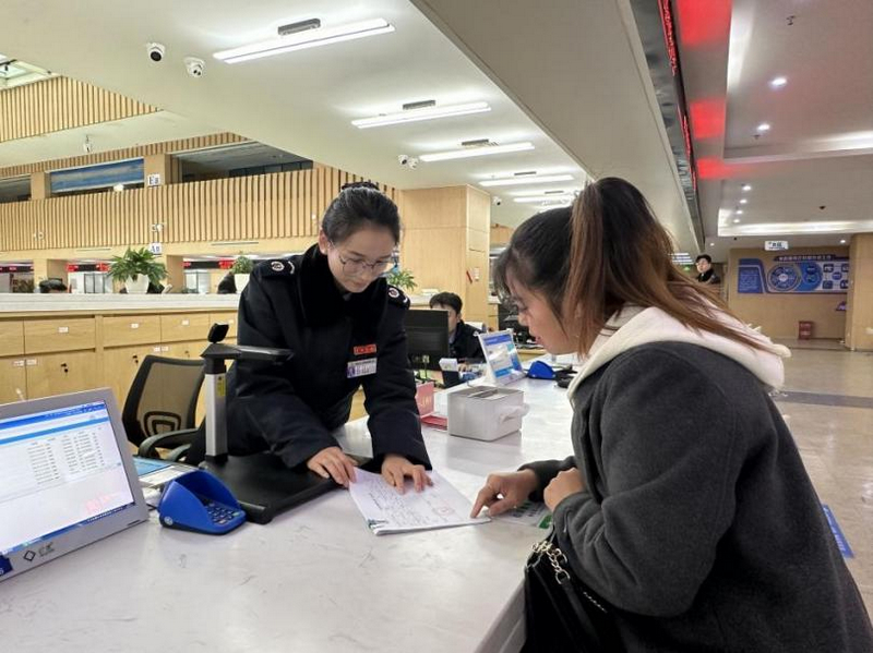 圖為 “疑難雜症處理專窗”工作人員為納稅人辦理涉稅業務。李琪攝