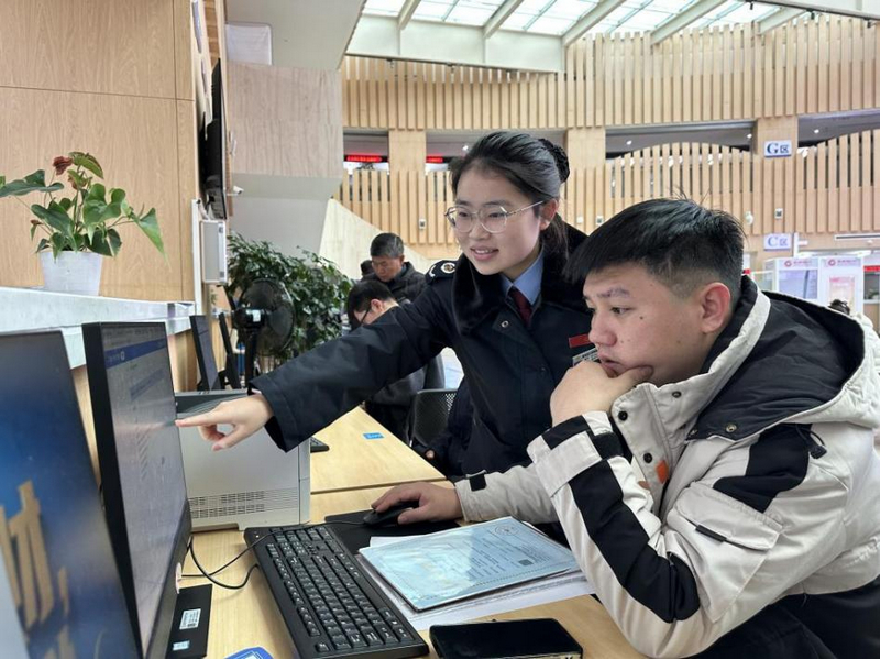 工作人員輔導個體戶辦理跨區域涉稅業務。李琪攝