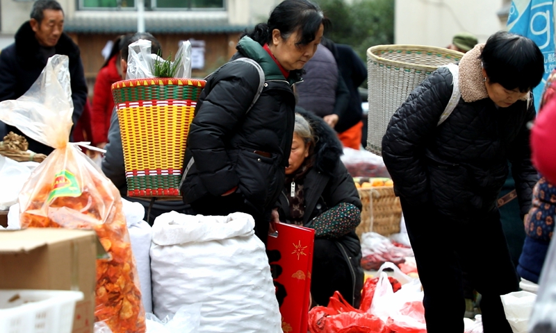 2、群众们穿梭集市挑选商品。 陈桂良摄