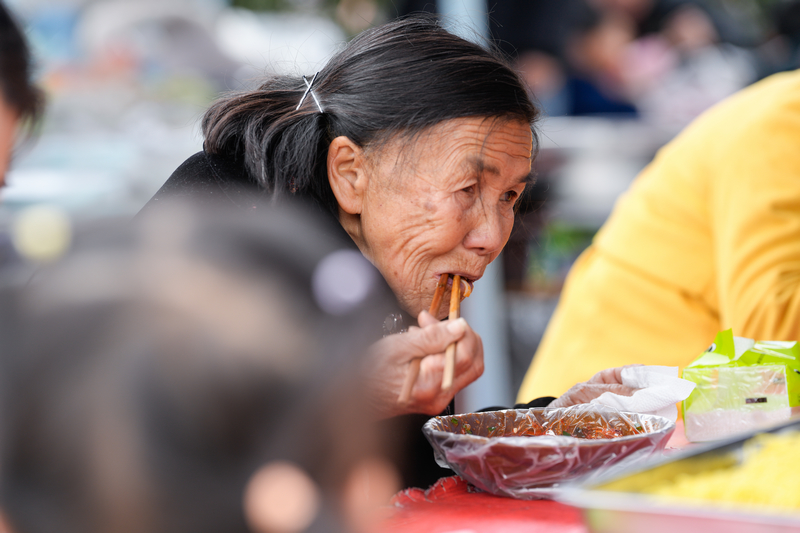 1月23日，凱裡下司大集上一位80多歲的奶奶在吃著溫暖的米粉。