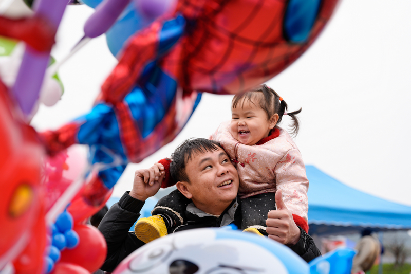 1月23日,凯里下司大集小女孩开心地坐在爸爸的肩膀上。