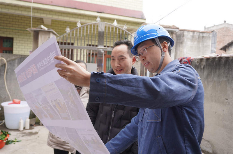 工作人员正对村民们讲解着用电安全知识。