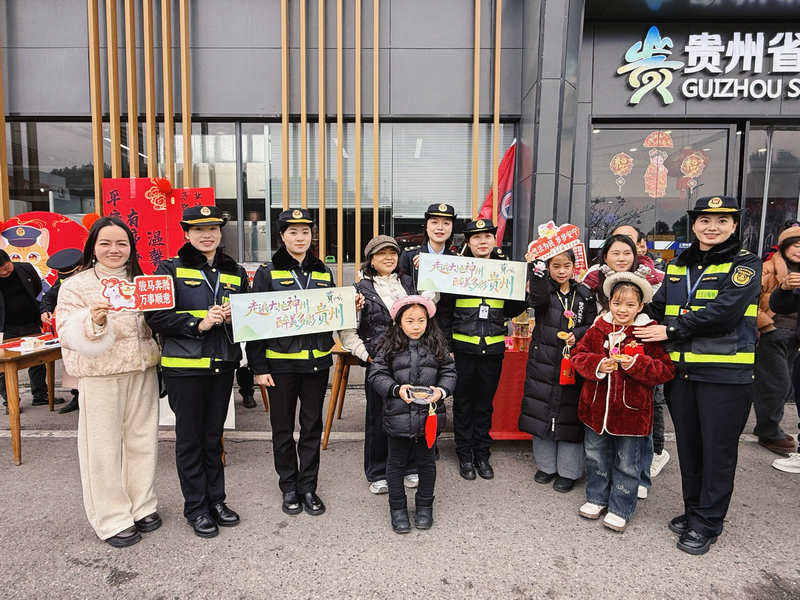 執法人員與司乘、游客共同手持“走遍大地神州 最美多彩貴州”橫幅合影，推動交旅融合。