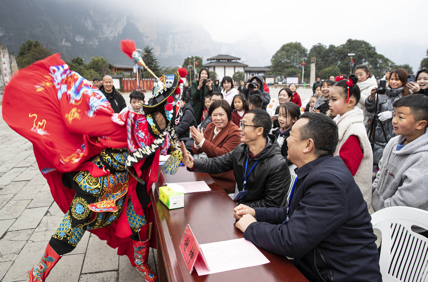 2026年2月3日，贵州省黔西市新仁苗族乡化屋村同心广场，村民和游客零距离观看川剧变脸。