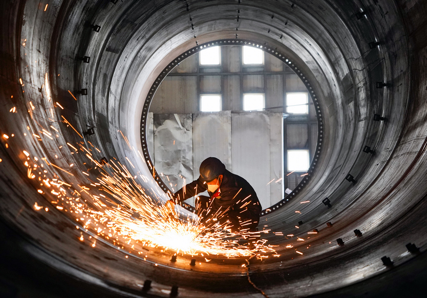 在位於貴州威寧經濟開發區的貴州保龍設備制造有限公司風電塔筒生產車間，工人在對焊接好的塔筒進行焊接口打磨。趙慶能攝