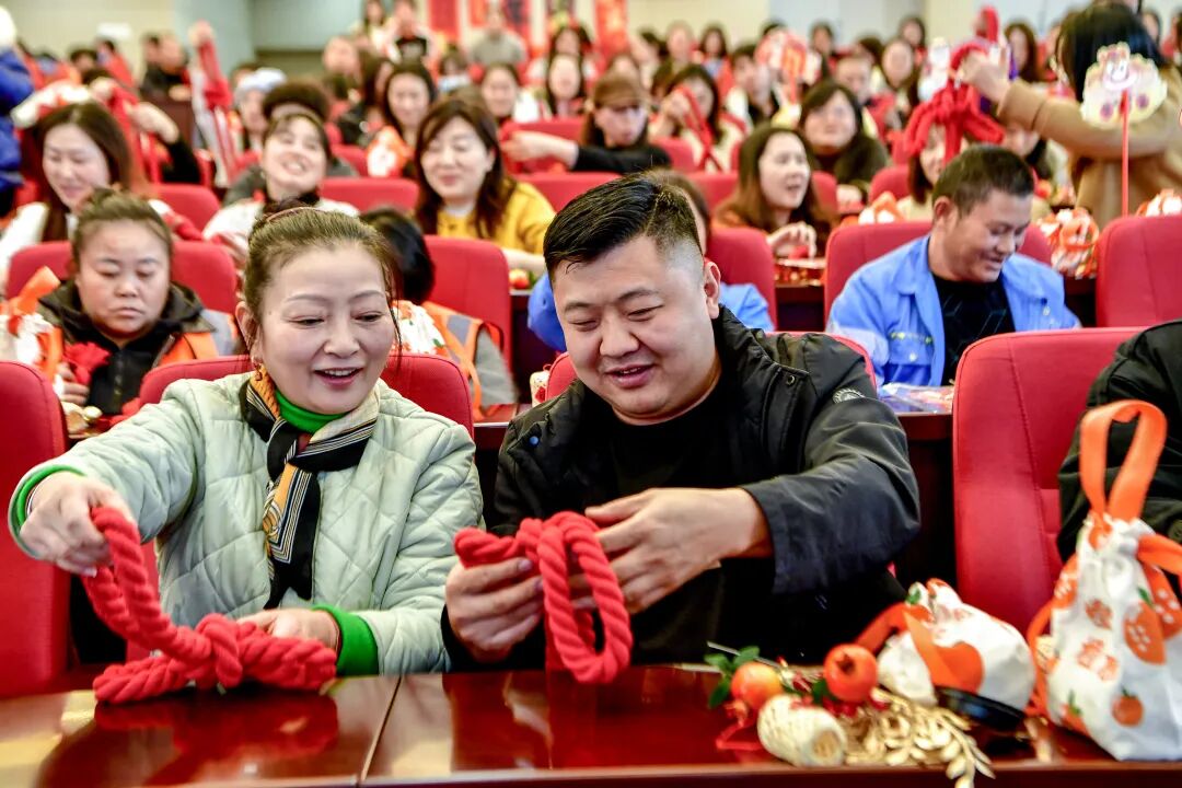在老师的指导下，职工们认真制作中国结。