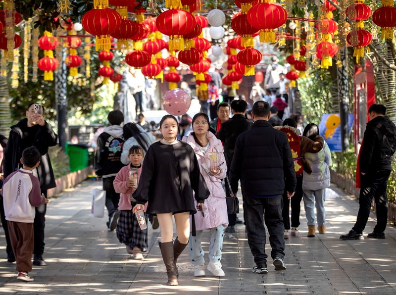 市民在挂满红灯笼的黔西市水西公园游玩。