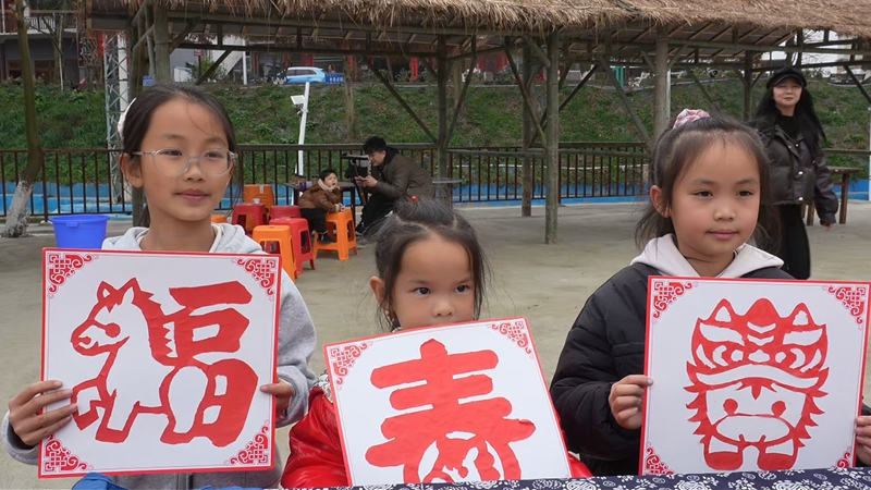 游客展示自己剪的剪紙作品。