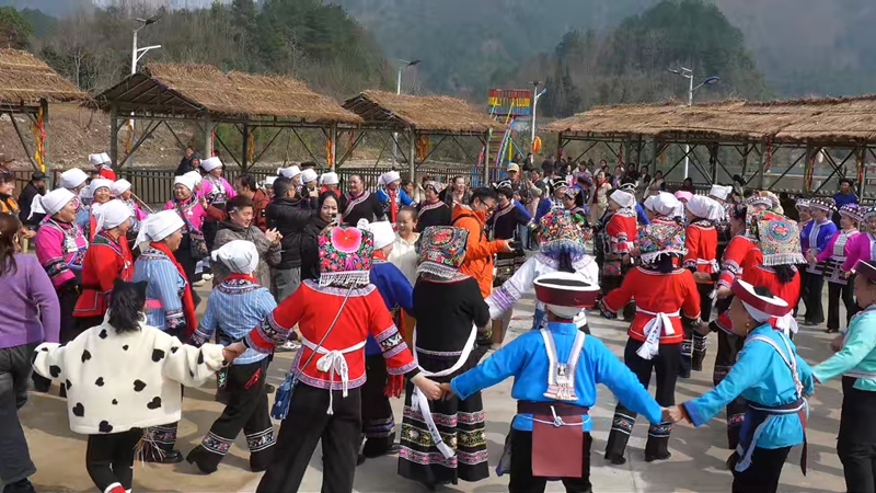 游客與少數民族群眾共跳民族舞。