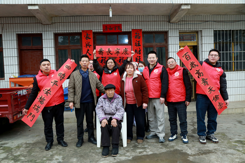 社工志願者與貴州省遵義市播州區八裡社區102歲淳祖開老人一家照全家福。