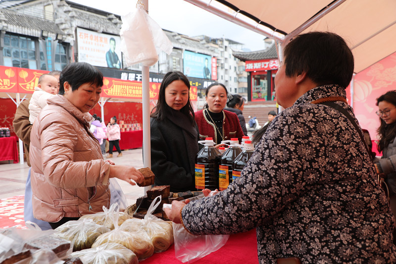 顧客在石阡縣年貨市場選購豆干。