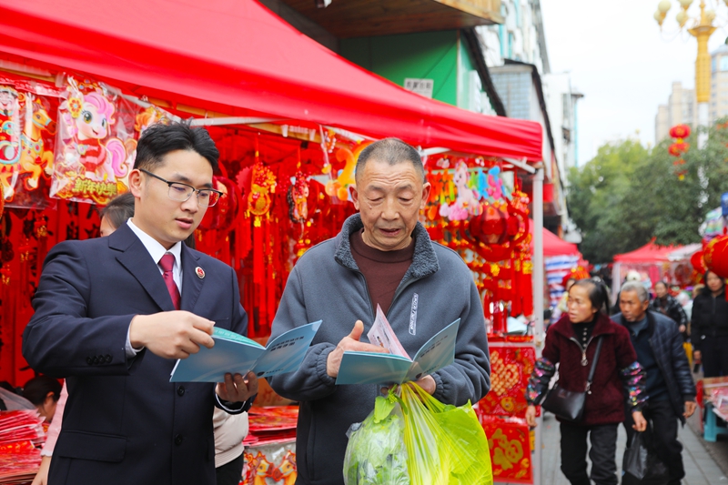 2026年2月11日，施秉縣檢察院干警在給前來採購年貨的群眾講解相關法律知識。吳桂花攝
