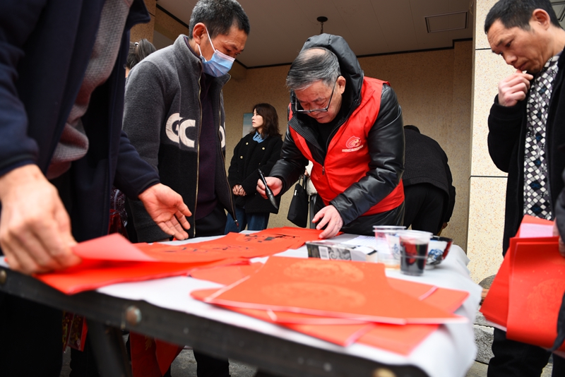 2月12日，贵州省黔西市甘棠镇大锡社区，志愿者正在给村民写春联。