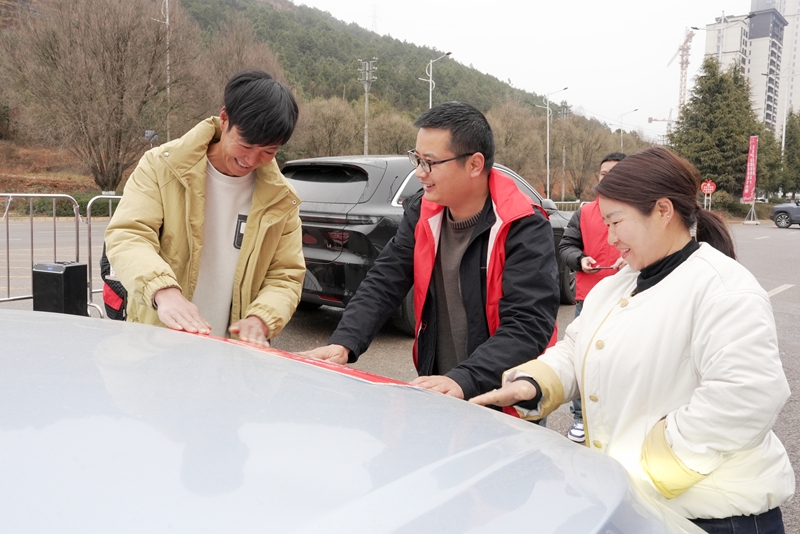 圖為2月19日，在威寧自治縣2026年春節“五個一批”點對點自駕返崗歡送儀式現場，返崗群眾正在貼號碼牌。（趙慶能 攝）.JPG