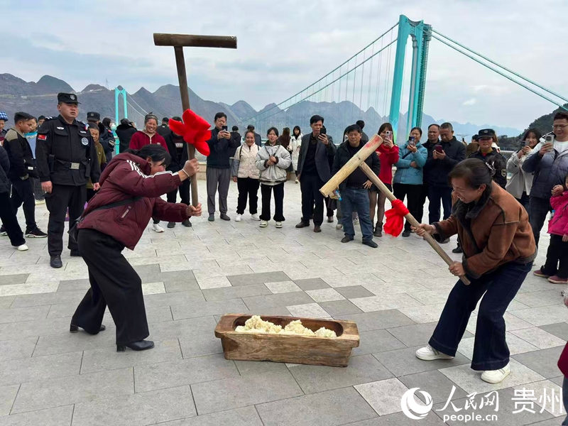 游客以大桥为背景参与打糍粑。人民网记者 高华摄