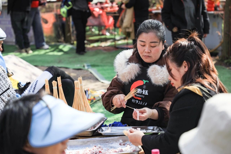 9、龙娜与家人在樱花树下穿肉串。