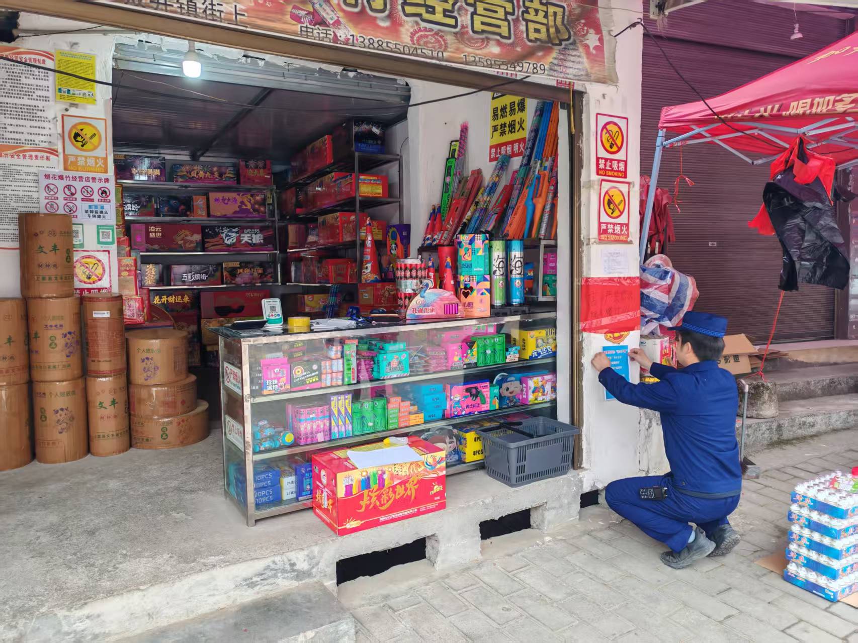 专职消防员在烟花爆竹门店门口张贴“五严禁、三务必”措施。