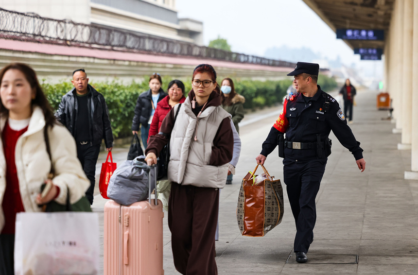 鐵路公安民警在幫助旅客搬運行李。 