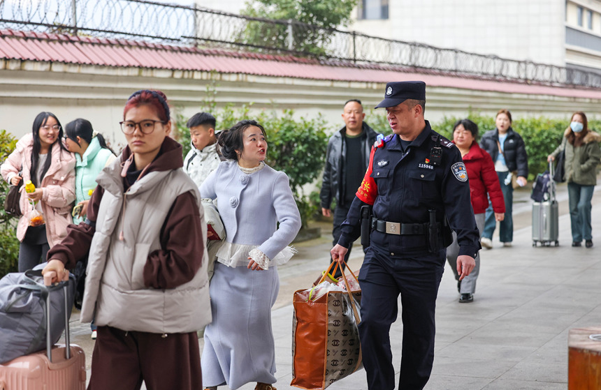 铁路公安民警在帮助旅客搬运行李。 