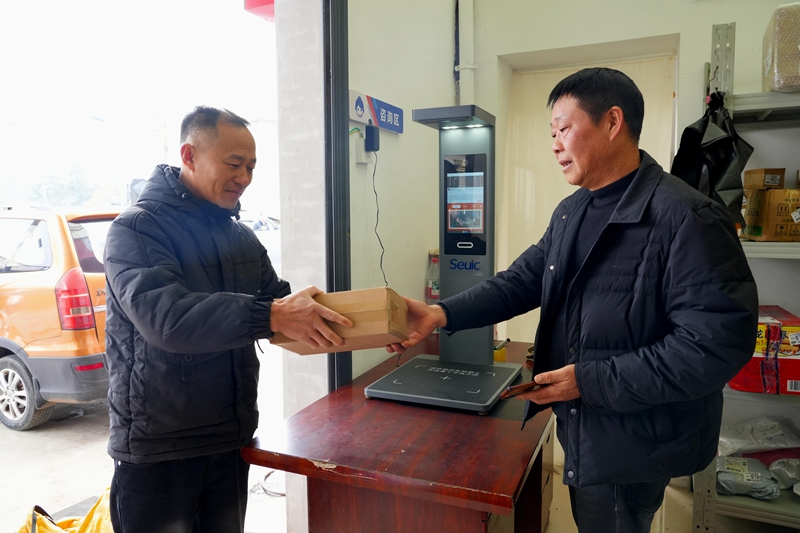 2、大壩鎮紅陽村交郵融合末端服務點 ，村民領取包裹。