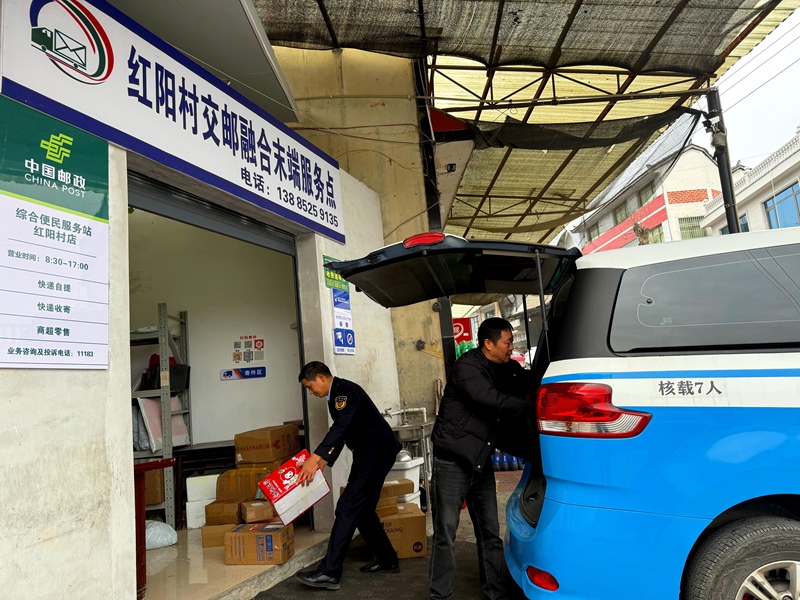 4、公交到達大壩鎮紅陽村交郵融合末端服務點， 負責人在下貨。
