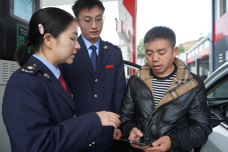 惠水縣稅務局工作人員輔導納稅人開票。