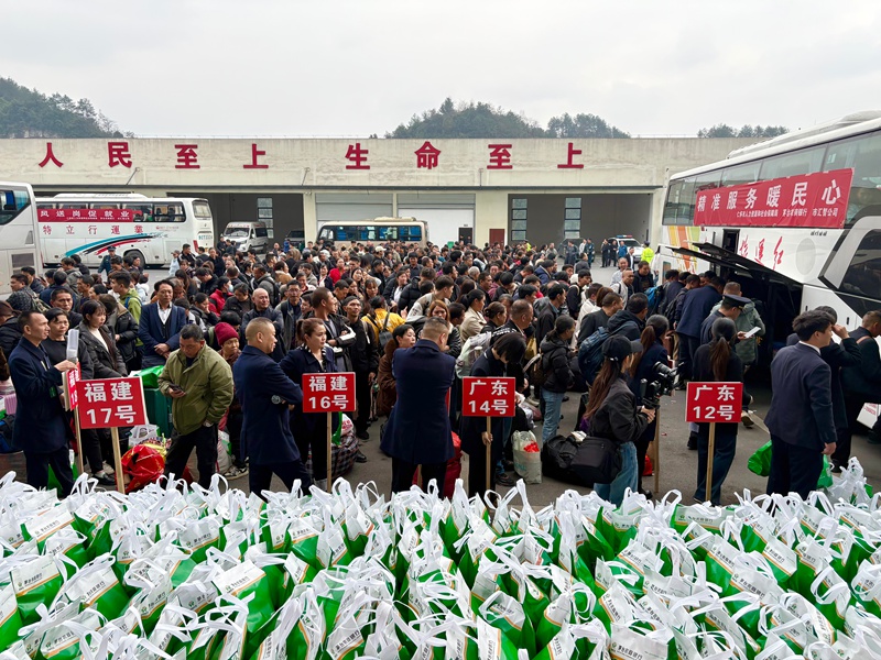 1、務工人員攜帶行囊，在工作人員引導下有序排隊登車。