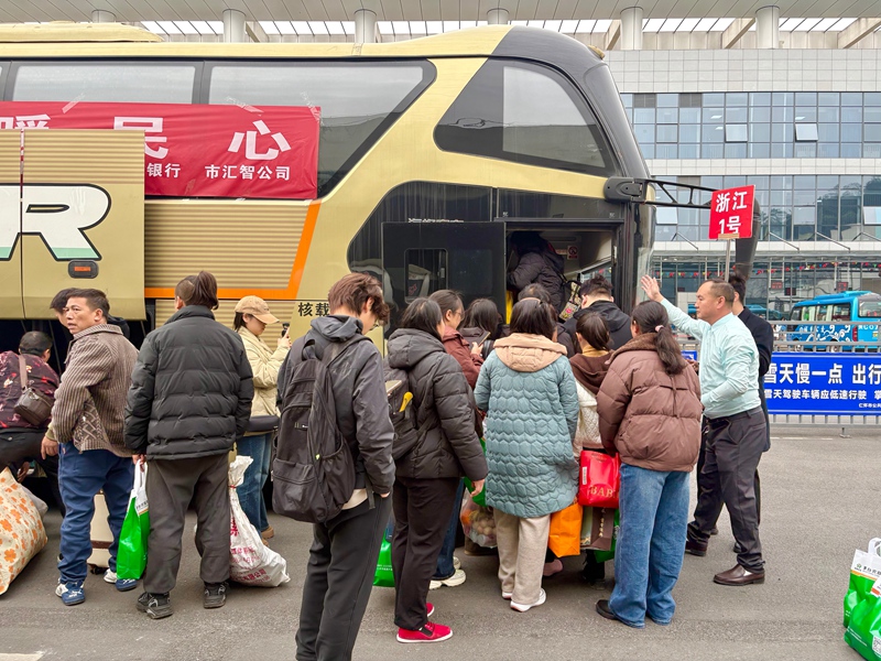 2、務工人員攜帶行囊，在工作人員引導下有序排隊登車。