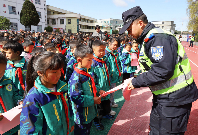 威寧自治縣公安局六橋派出所民警在白馬小學發放法治法治宣傳資料，並耐心為學生講解。