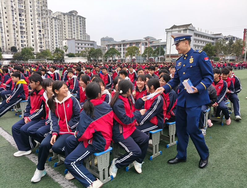 施秉县消防宣传员在施秉县民族中学向学生发放《中小学生消防安全知识读本》。