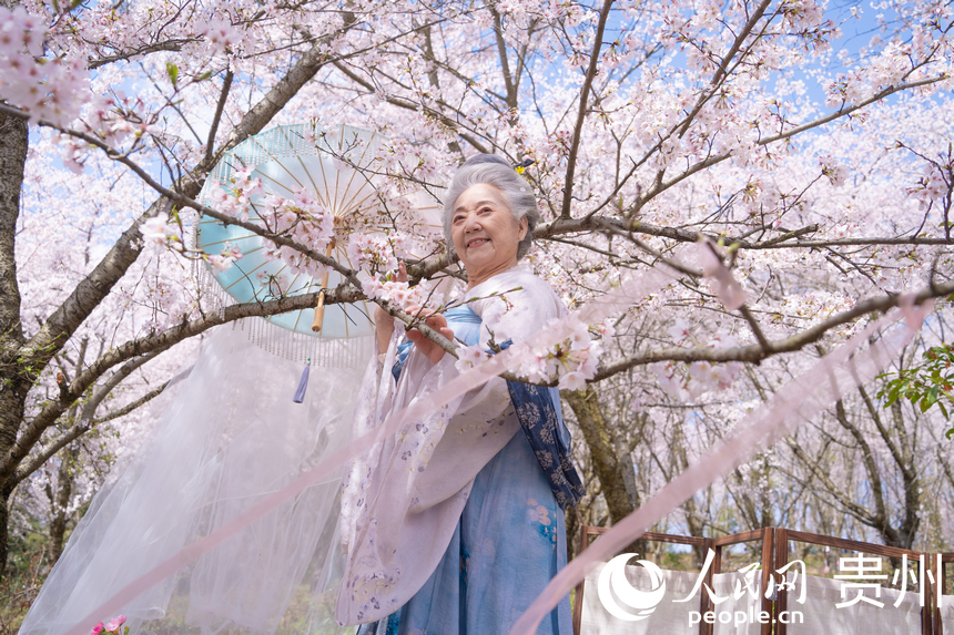 游客在樱花树下拍照。人民网 阳茜摄