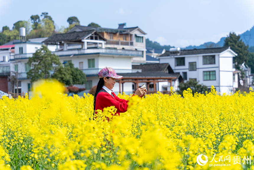 游客在馬頭村油菜花田內打卡拍照。人民網記者 涂敏攝