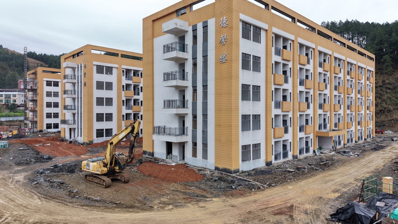 4、挖掘机在填平路面。（沈启照 摄）