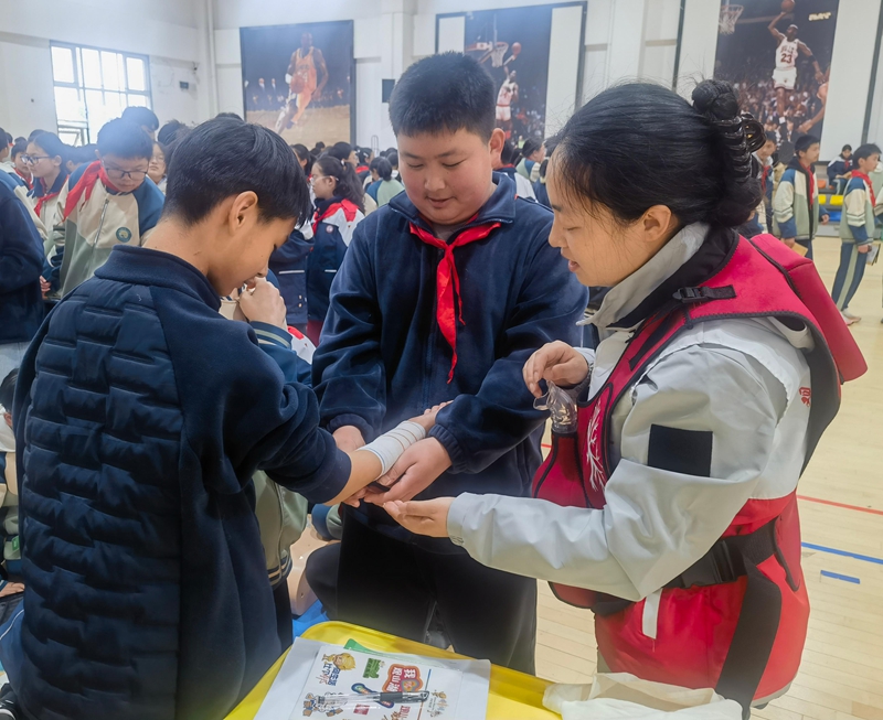 红十字志愿者指导学生进行应急救护实操。罗正秀 摄.jpg