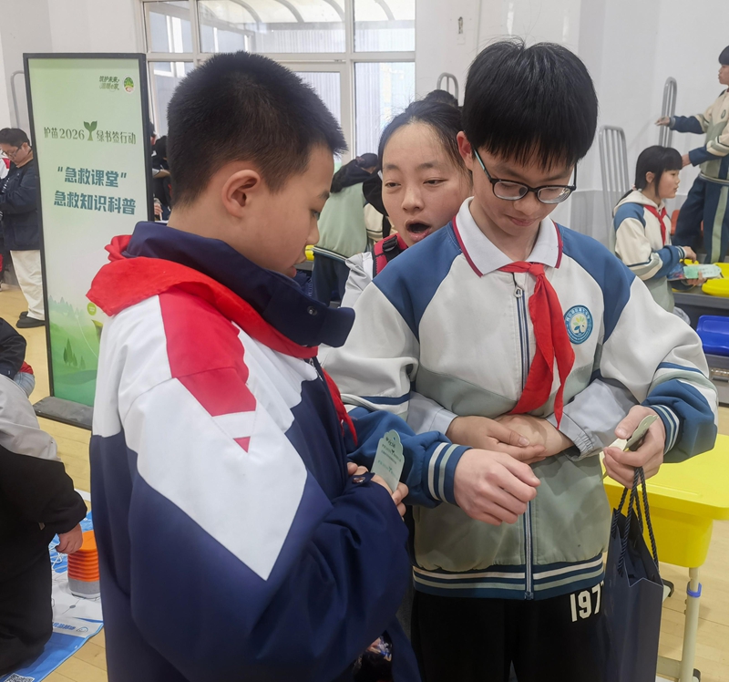 红十字志愿者指导学生进行应急救护实操。罗正秀 摄.jpg