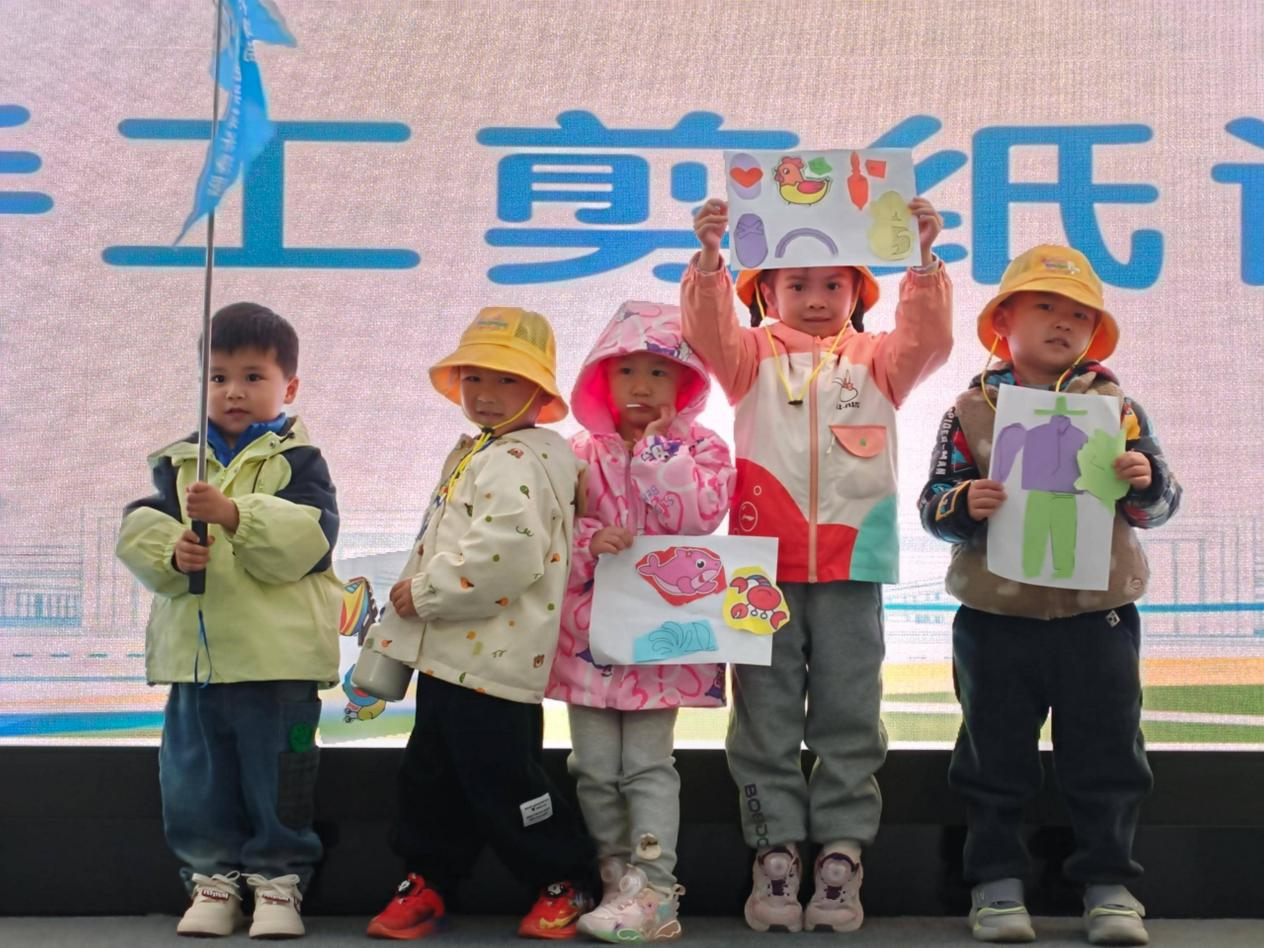幼儿组孩子们展示手工剪纸作品。