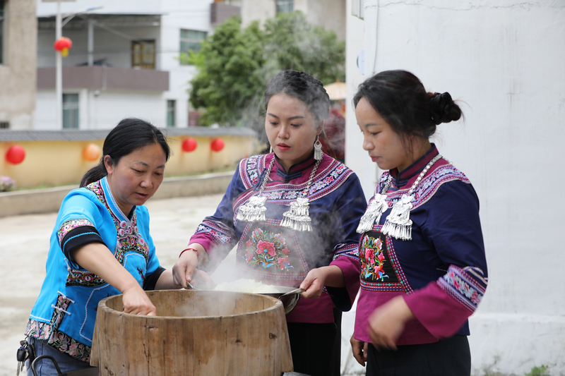 布依妇女正在蒸煮糯米。