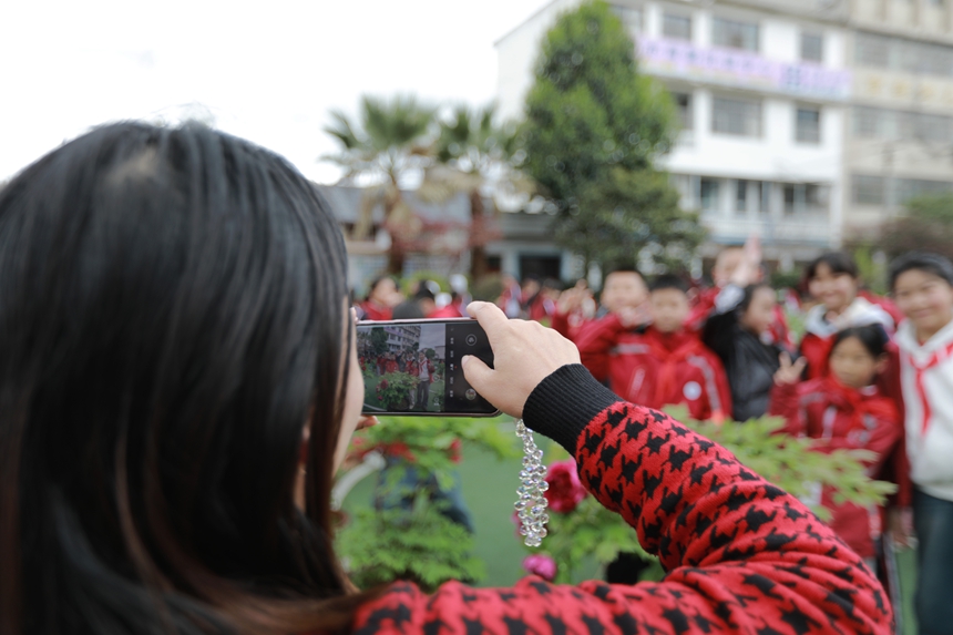 2026年3月31日，贵州省黔西市第一小学的老师和学生在校园里欣赏牡丹花，并拍照留影。