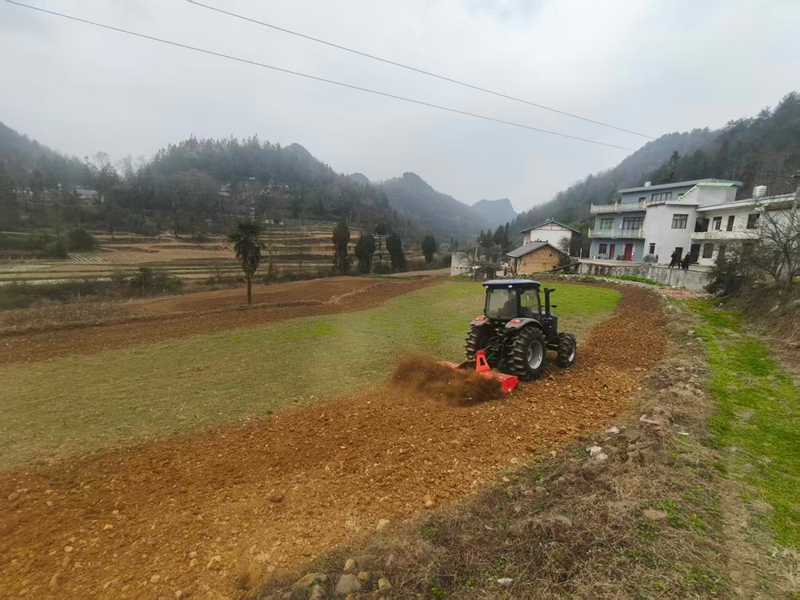 农机手正在驾驶农耕机翻耕土地。