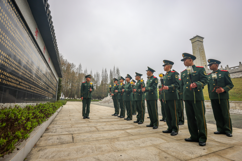 该支队官兵在烈士英名墙下讲述英烈的感人事迹。