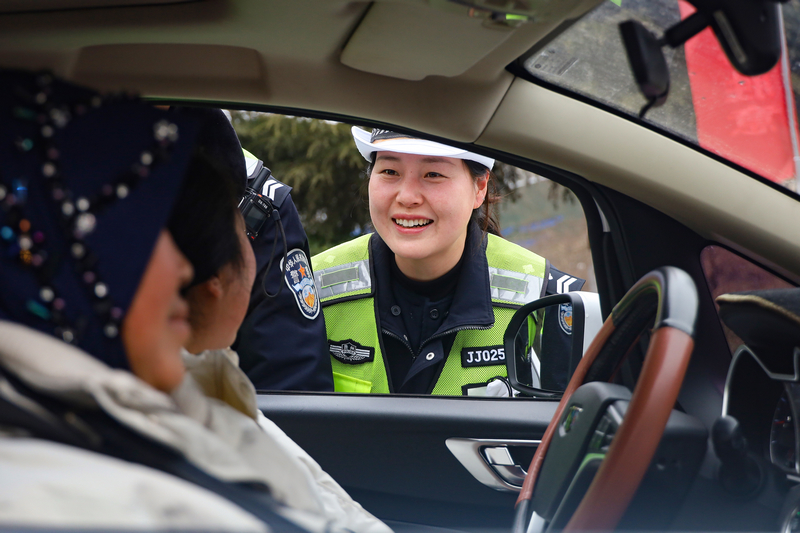 在威宁自治县“点对点”有组织劳务输出欢送仪式现场，交警在叮嘱司乘人员行车安全事项。赵庆能摄
