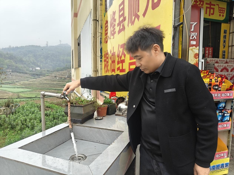 村民打开水龙头展示水量水质情况.jpg