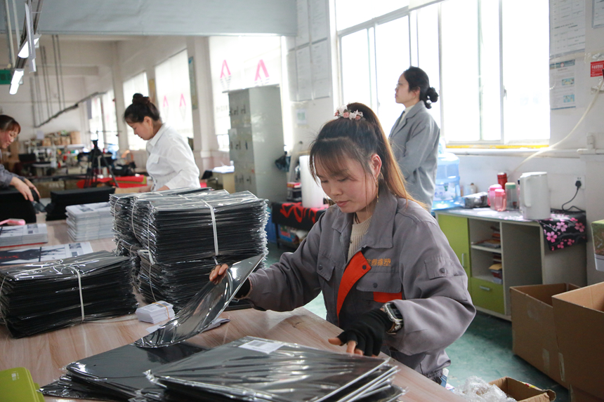 图为工人们忙着赶制订单。梅亚军摄