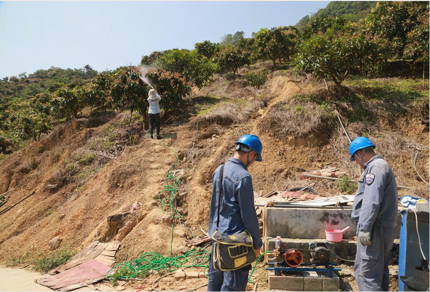 工作人员检查果农浇灌用电设备。
