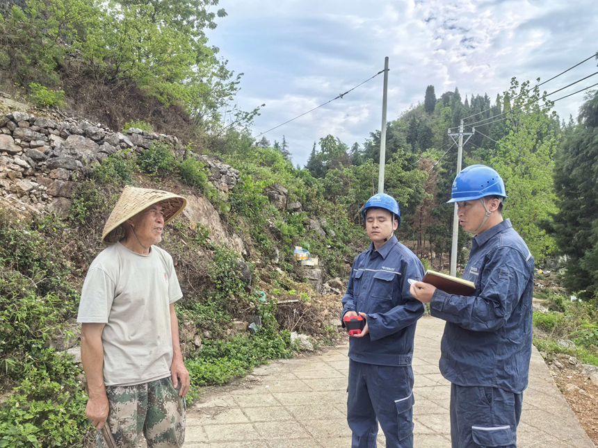 與當地群眾了解用電情況。陳舉攝