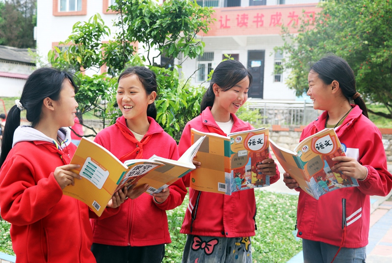 在黔西市铁石苗族彝族乡铁石小学，学生们正在校园树荫下流读书学习感想。