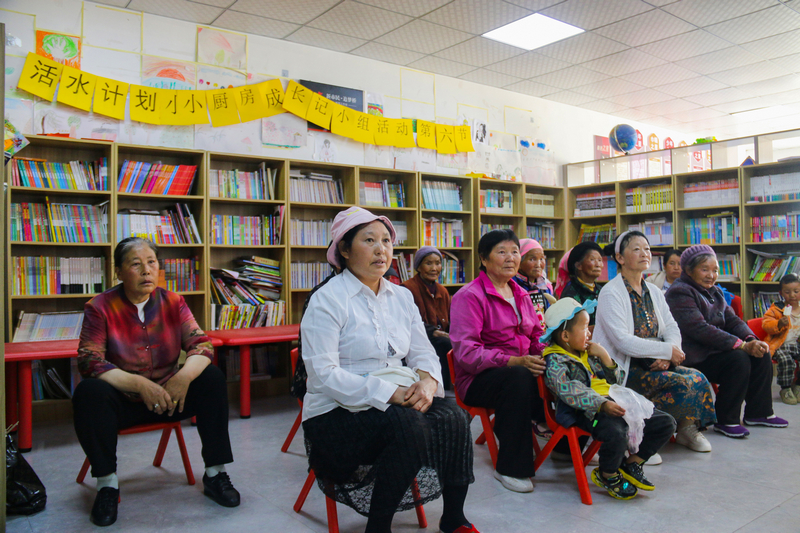 在威宁自治县开华街道社工站，老年人带着孩子在观看爱国电影。赵庆能摄