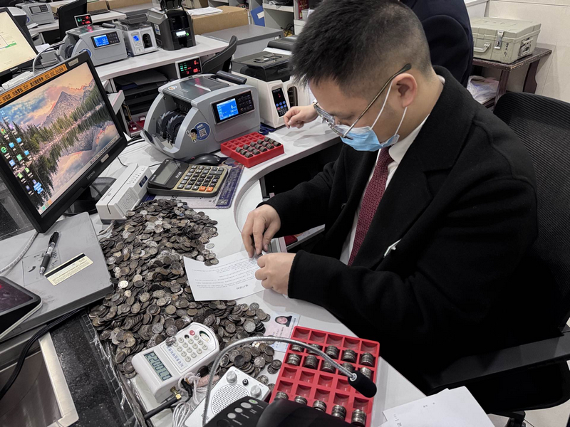 麻江农商银行工作人员为客户清点“火烧硬币”。
