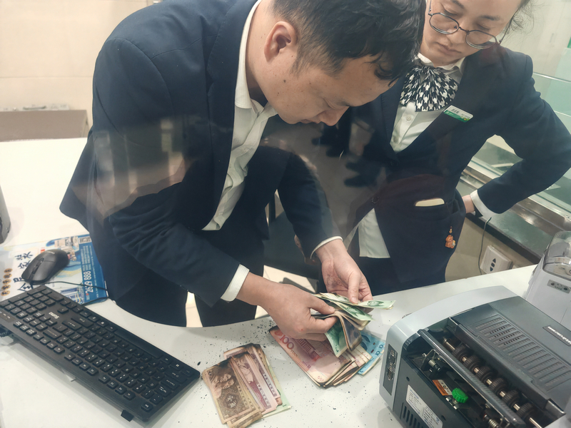 麻江农商银行工作人员为客户清点“火烧硬币”。